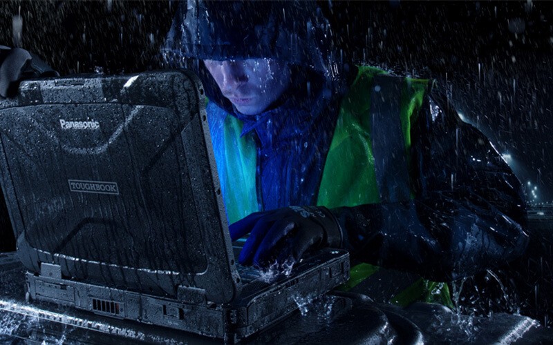Man using Toughbook while raining