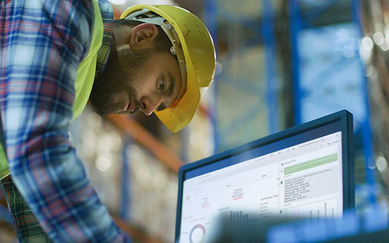 Qlik lifestyle man working on laptop in warehouse