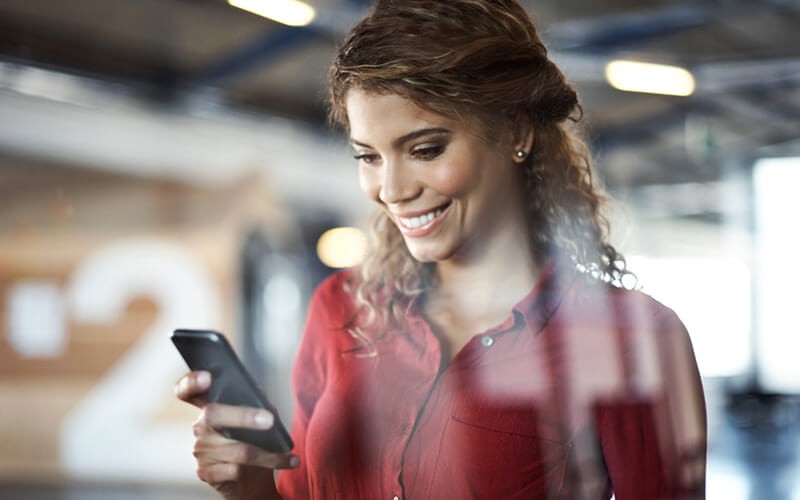 Nonstop security and compliance Woman smiling on mobile phone