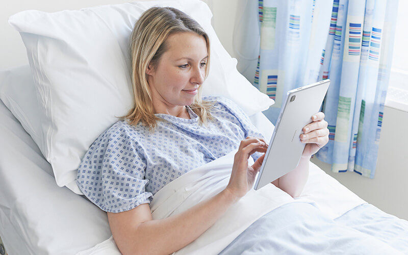 Patient in bed using a tablet