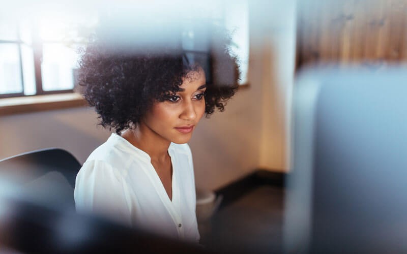 Young professional woman sitting at laptop 