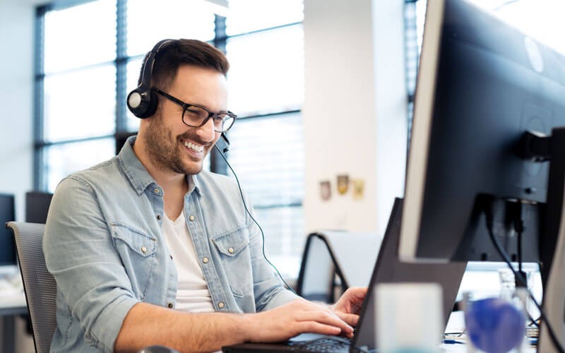 Man smiling on phone and computer