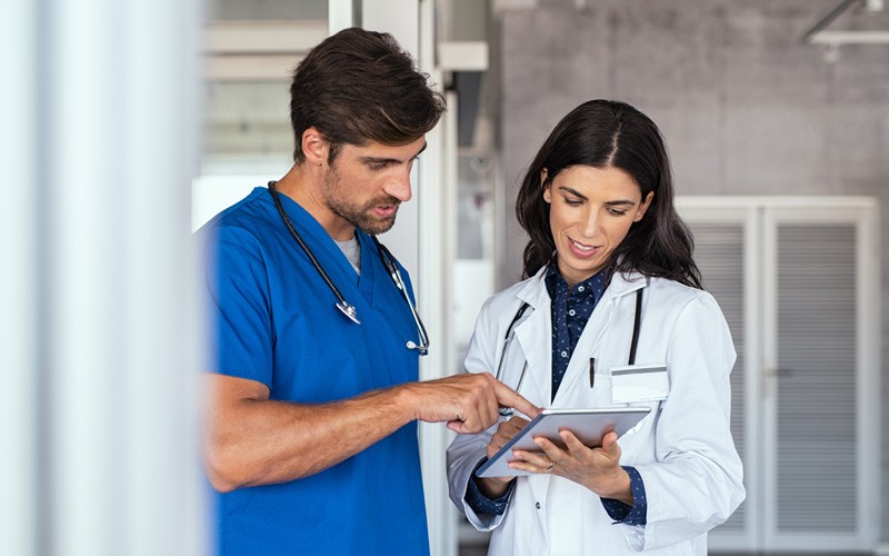 Strategic technology investments help your organization Two doctors collaborating over tablet device