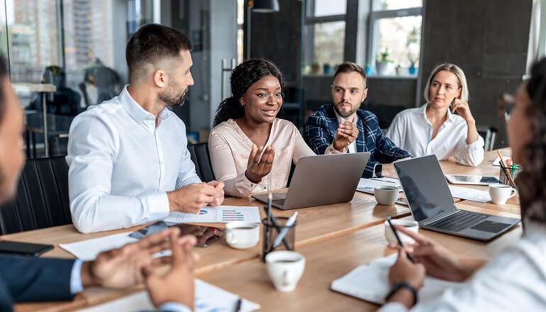 Immediately see information about expiring contracts and sort by preferred action. Business professional talking in meeting with a laptop.