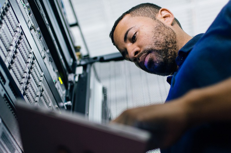 IT network administrator reviewing business data from hyperconverged virtual machine in data center